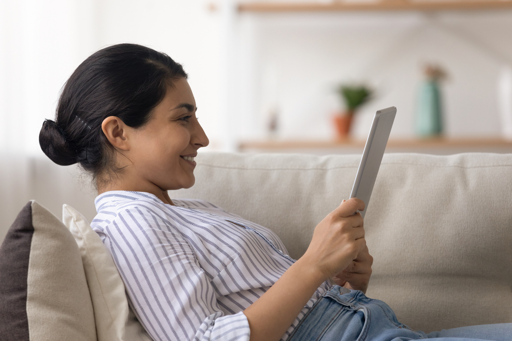 Side,View,Of,Happy,Indian,Woman,Recline,On,Pillows,At